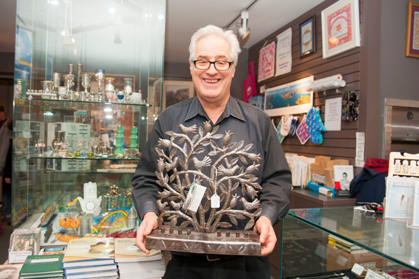 Covering Battery Park City, Nov. 20, 2013 1 Downtown Express photos by Terese Loeb Kreuzer Warren Shalewitz, manager of the shop at the Museum of Jewish Heritage in Battery Park City, holding a menorah made in Haiti from a discarded oil drum by an artisan named Evenson. Hanukkah starts at sundown on Nov. 27 and runs through Dec. 5.