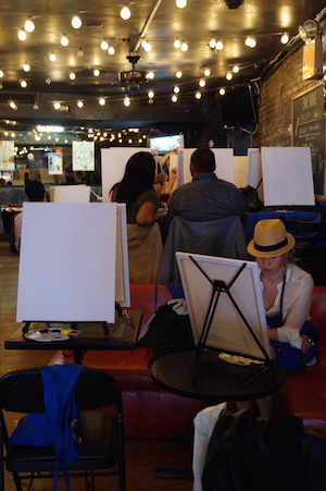 Where booze and brushwork mix 6 Attendees to Bar Nine's Painting Circle event sit down by their blank canvasses and start sipping their drinks. Photo by Nicole Javorsky.