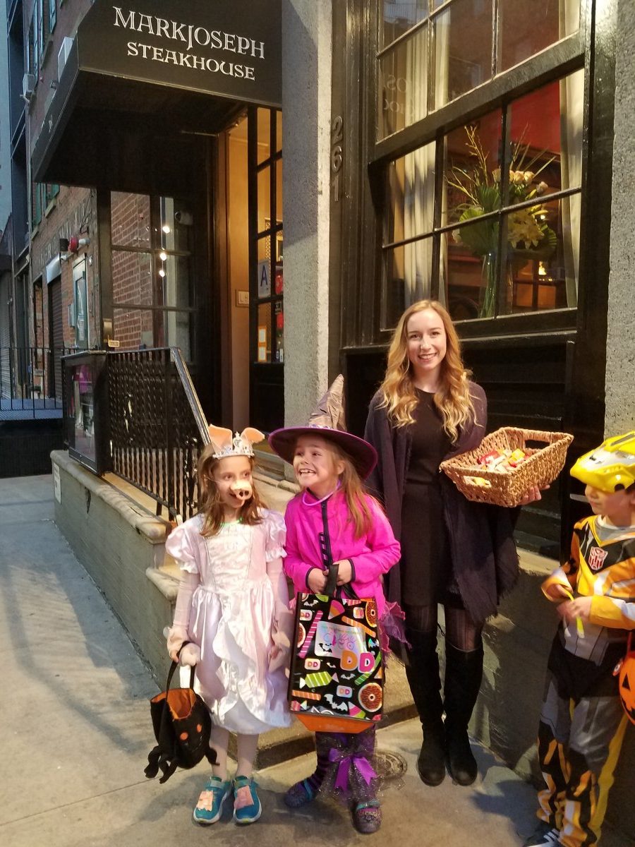 Mark Joseph hostess Nicole Schafer hands out sweets to eager trick-or-treaters on Halloween