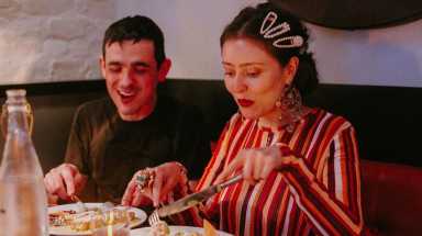 Juli Ronderos of Salt Cathedral dives into her meal before performing at their June dinner party at Guadalupe Inn.