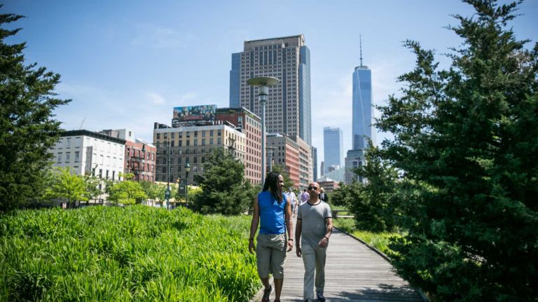 People walk in Hudson River Park in Hudson Square in Manhattan