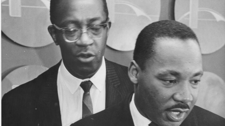 Dr. Martin Luther King, Jr., leaves the press room at Kennedy International Airport on Dec. 16, 1964. King had just arrived from Sweden after receiving the Nobel Peace Prize. Behind King is a spokesman, Cleveland Robinson.