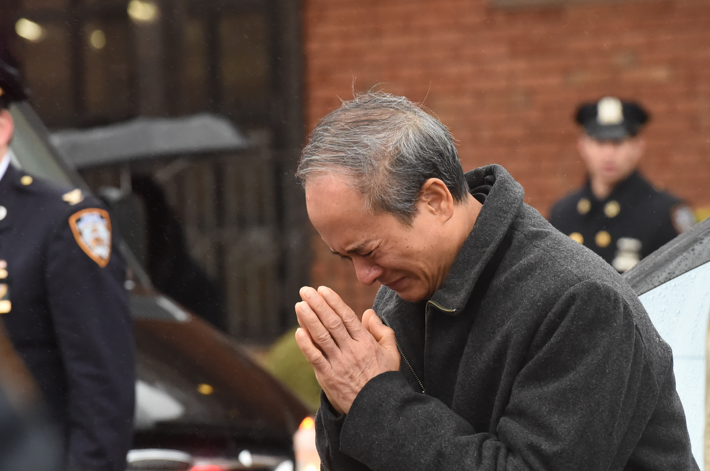 A father's grief: Police Officer Garman Chen's father bows to the line of police officers there to honor his son's memory
