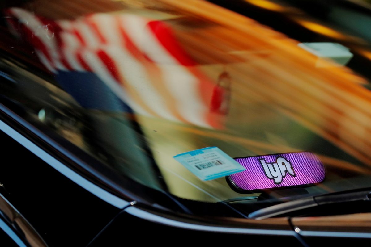 FILE PHOTO: A car with a Lyft logo in its window drives down a street as the company prepares for its upcoming IPO in New York