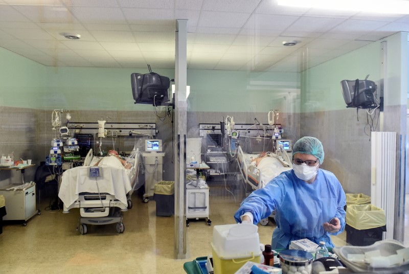 Medical worker wearing a protective mask and suit treats patients suffering from coronavirus disease (COVID-19) in an intensive care unit at the Oglio Po hospital in Cremona