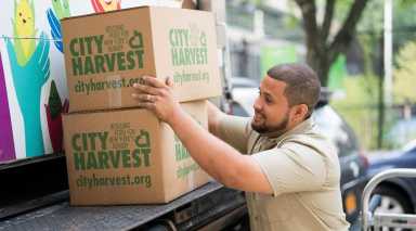City Harvest delivery man brings boxes of food for public.
