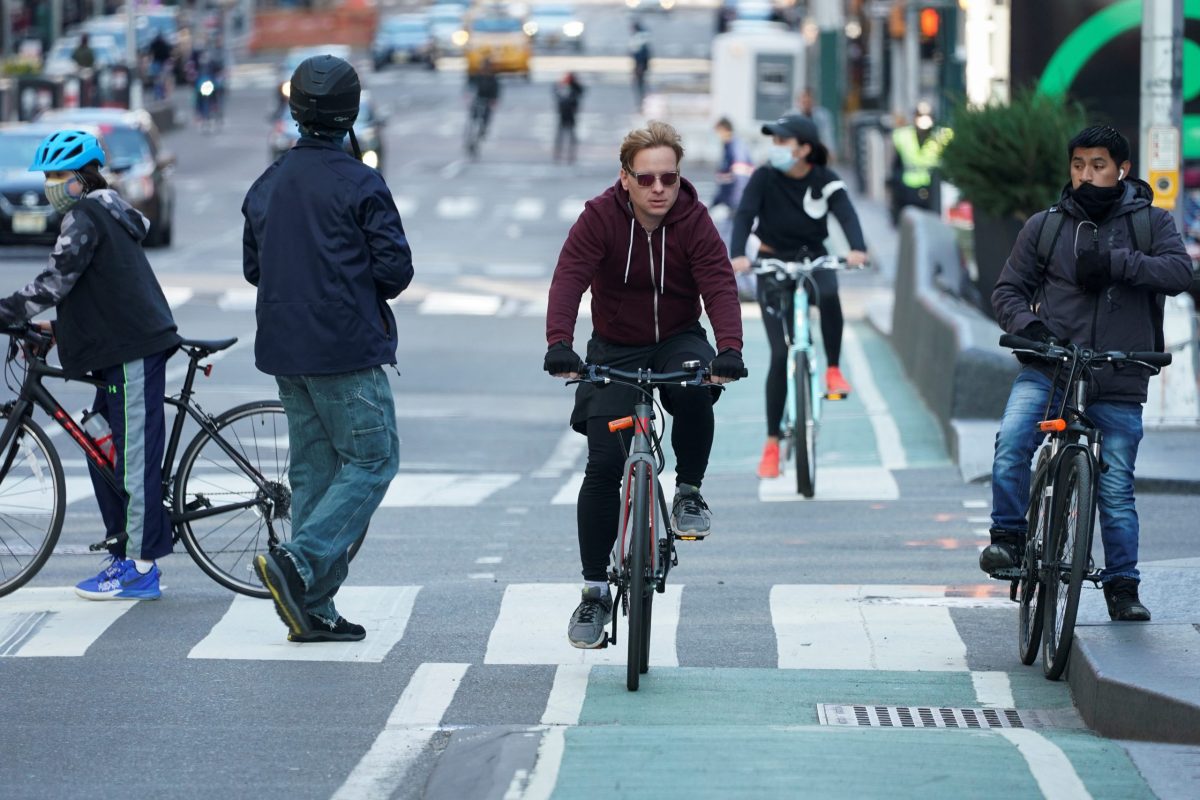 Cyclists ride through Times Square during evening rush hour in New York