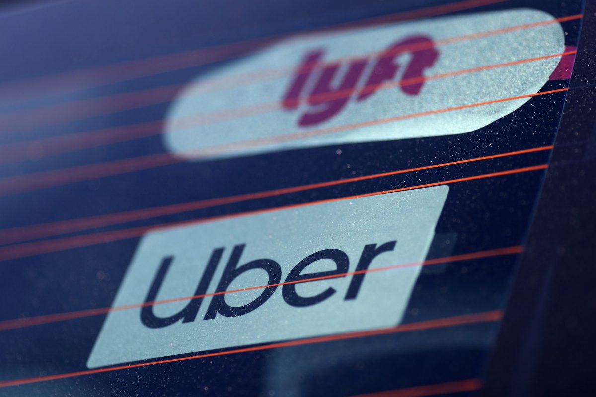 Uber and Lyft signs are seen on a car in Redondo Beach