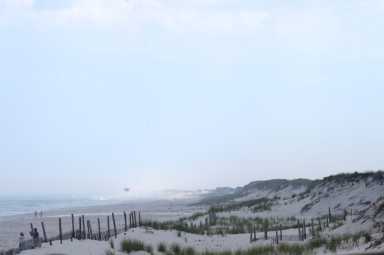 FILE PHOTO: Beach goers walk by the ocean in Seaside Park, New Jersey