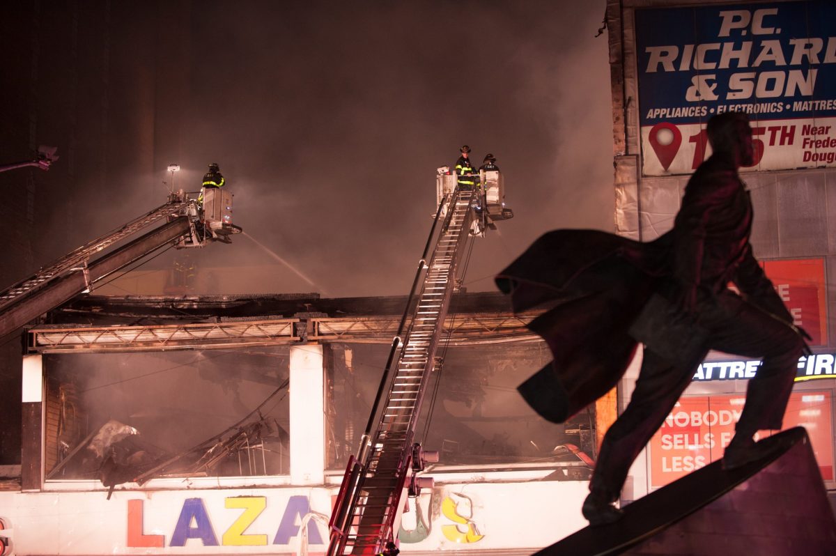 Firefighters force entry into a commerical building at 163 125 Street. A fire consumed the second floor and third floor of a store.