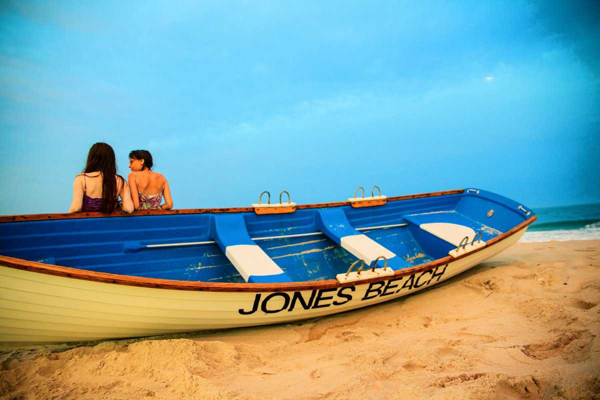 Two girls stay at the Jones Beach at the sunset
