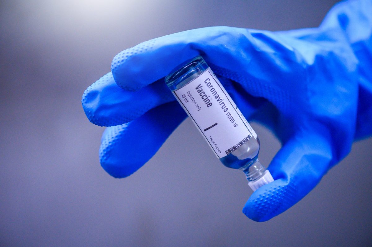 Hand holds Coronavirus Covid-19 Vaccine glass bottle