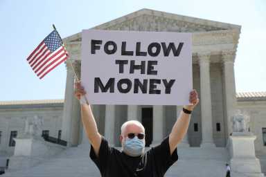 Demonstrator holds sign outside the U.S. Supreme Court in Washington