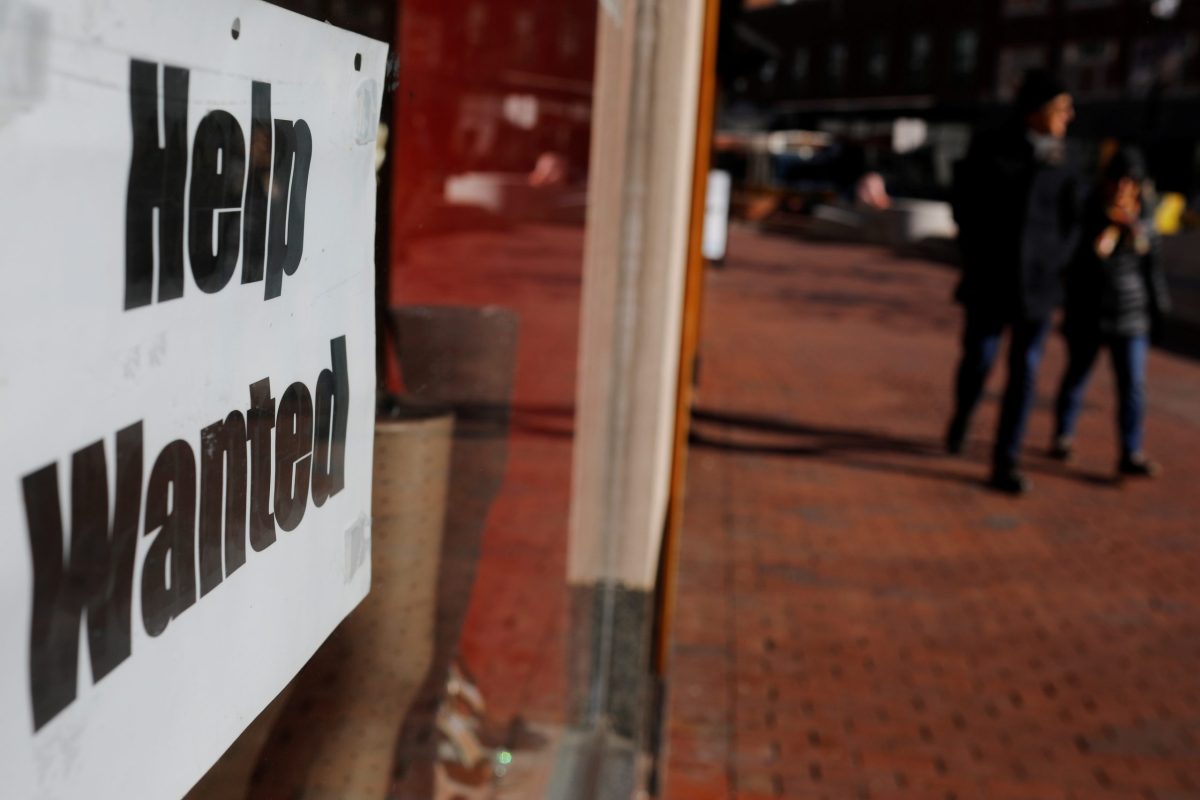 A “Help Wanted” sign sits in the window of a shop in Harvard Square in Cambridge