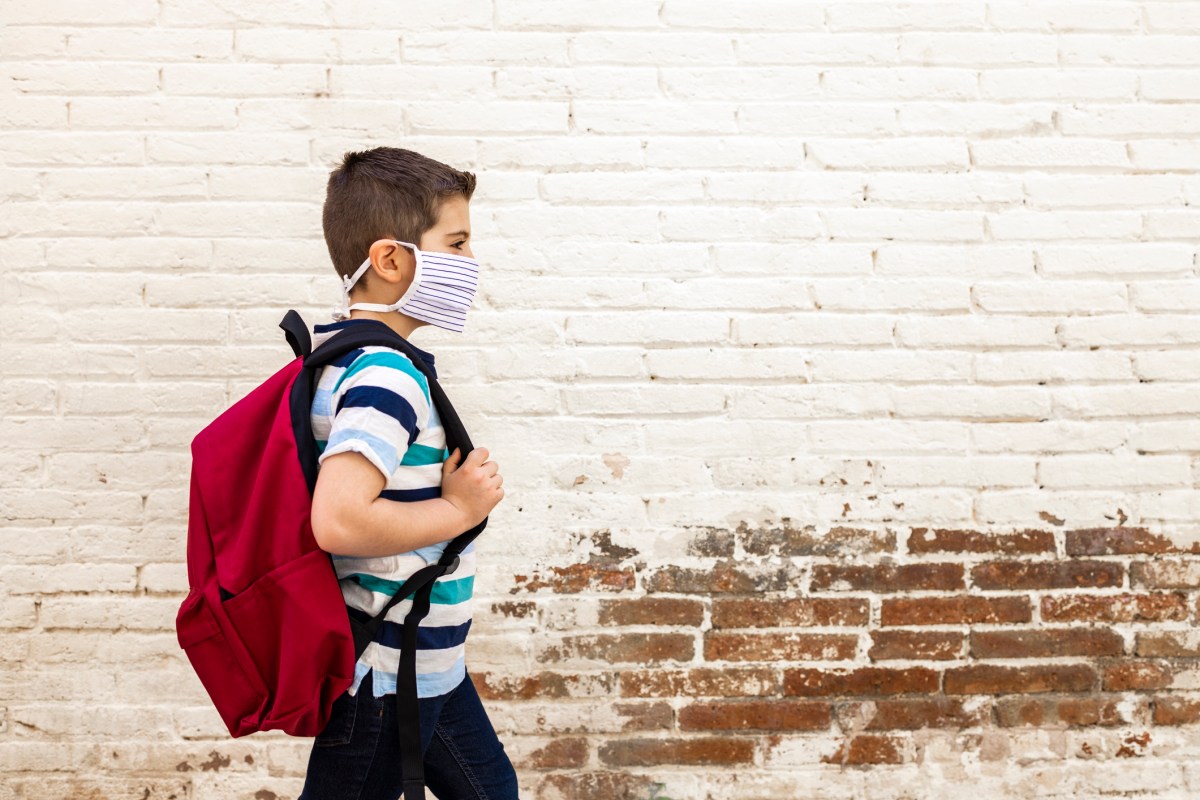Little boy going to school with protective mask