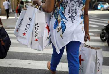 A woman carries shopping bags from Macy’s department store in midtown Manhattan in New York