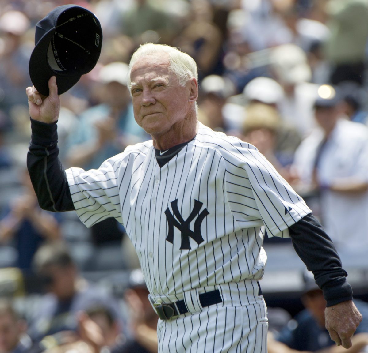 Hall of Famer Whitey Ford tips his cap as he runs onto the field during introductions for the 65th Old Timers’ Day game in New York