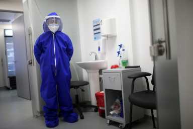 FILE PHOTO: A nurse wearing protective gear is seen inside a coronavirus disease (COVID-19) sampling room of the Synlab laboratory