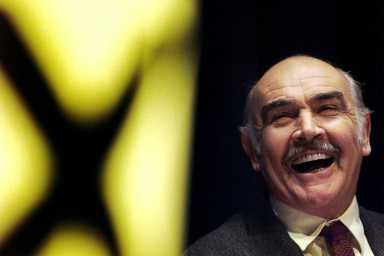 FILE PHOTO: Actor Sean Connery laughs as he listens to a speech by Alex Salmond at a Scottish National Party rally at the Edinburgh International conference centre