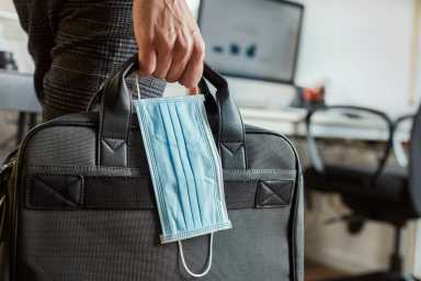 man with a briefcase and a surgical mask