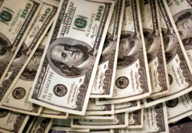 U.S. dollars are counted out by a banker at a bank in Westminster