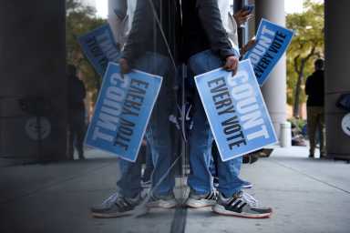 People gather to protest outside of a federal courthouse where a judge is deciding whether to throw out ballots cast at drive-through polling locations in Houston