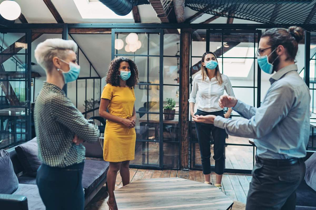 Group of entrepreneurs wearing masks and standing at a distance