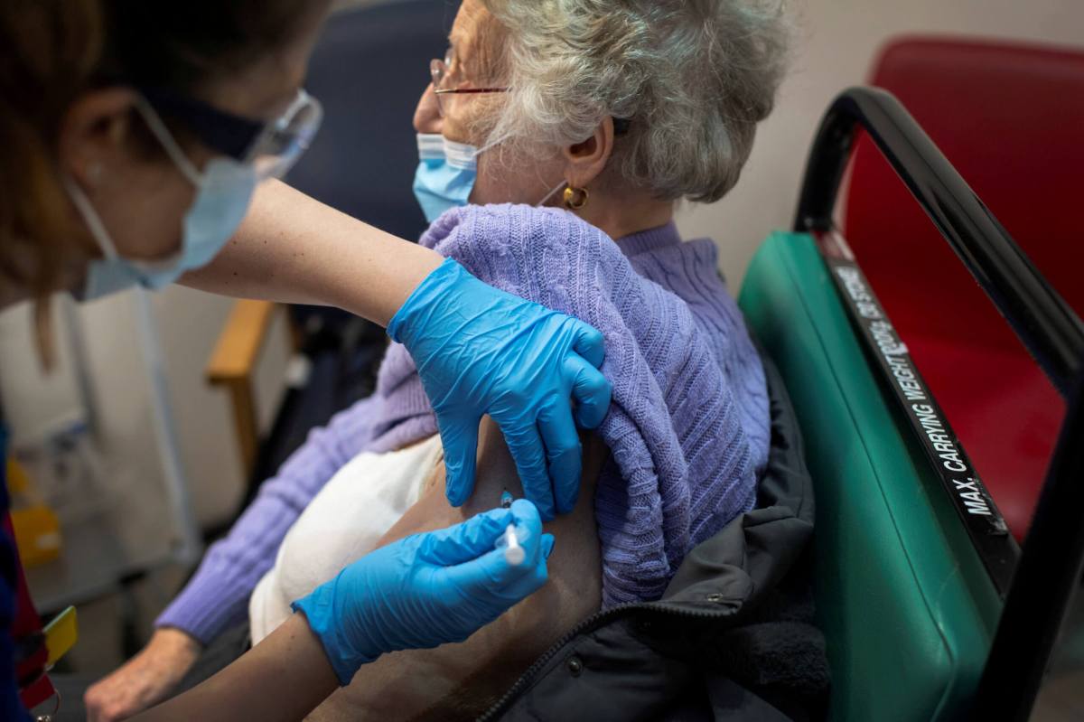 FILE PHOTO: A woman receives the first of two Pfizer/BioNTech COVID-19 vaccine jabs, at Guy’s Hospital in London