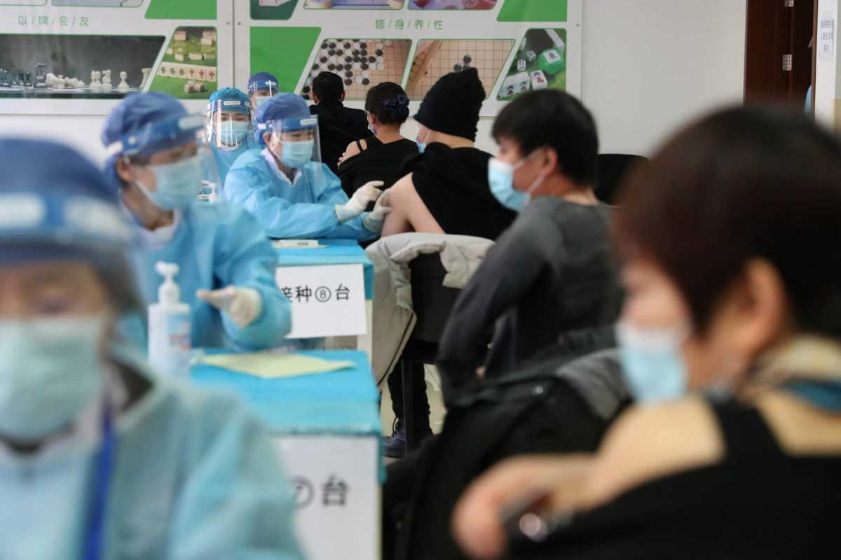 Medical workers administer COVID-19 vaccine at a makeshift vaccination site in Beijing