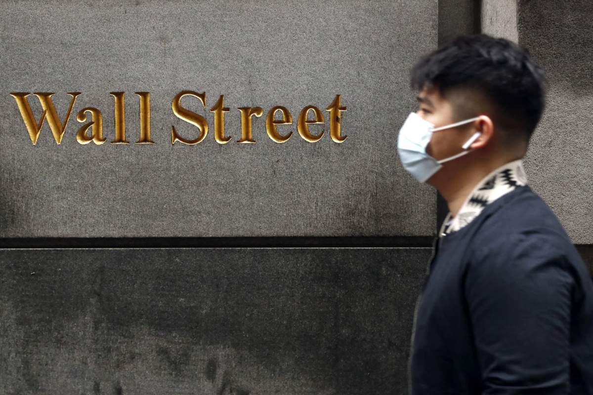 A man wears a protective mask as he walks on Wall Street during the coronavirus outbreak in New York