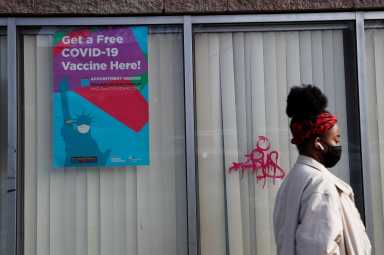 A woman walks by a NYC Vaccine Hub