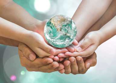 Green globe in family volunteer hands for earth day and CSR with people concept. Elements of this image furnished by NASA.