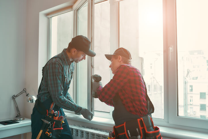 Provading best service. Men are installing a window