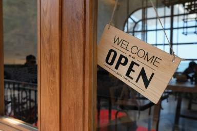 wooden open sign board hanging on door