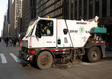 A sanitation truck cleans up 6th Ave after the Macy’s Thanksgiving Day Parade in New York