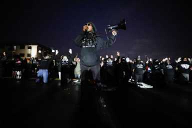 Activists confront officers following a march for Daunte Wright, who was shot and killed by former Brooklyn Center Police Officer Kim Potter, in Brooklyn Center, Minnesota