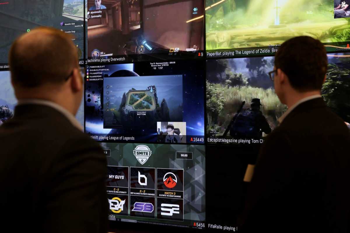 FILE PHOTO: Men look at a wall of real-time video game play in the lobby of Twitch Interactive Inc, a social video platform and gaming community owned by Amazon, in San Francisco, California