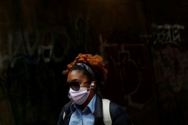 Woman walks under the subway in Brownsville section of the Brooklyn borough of New York City