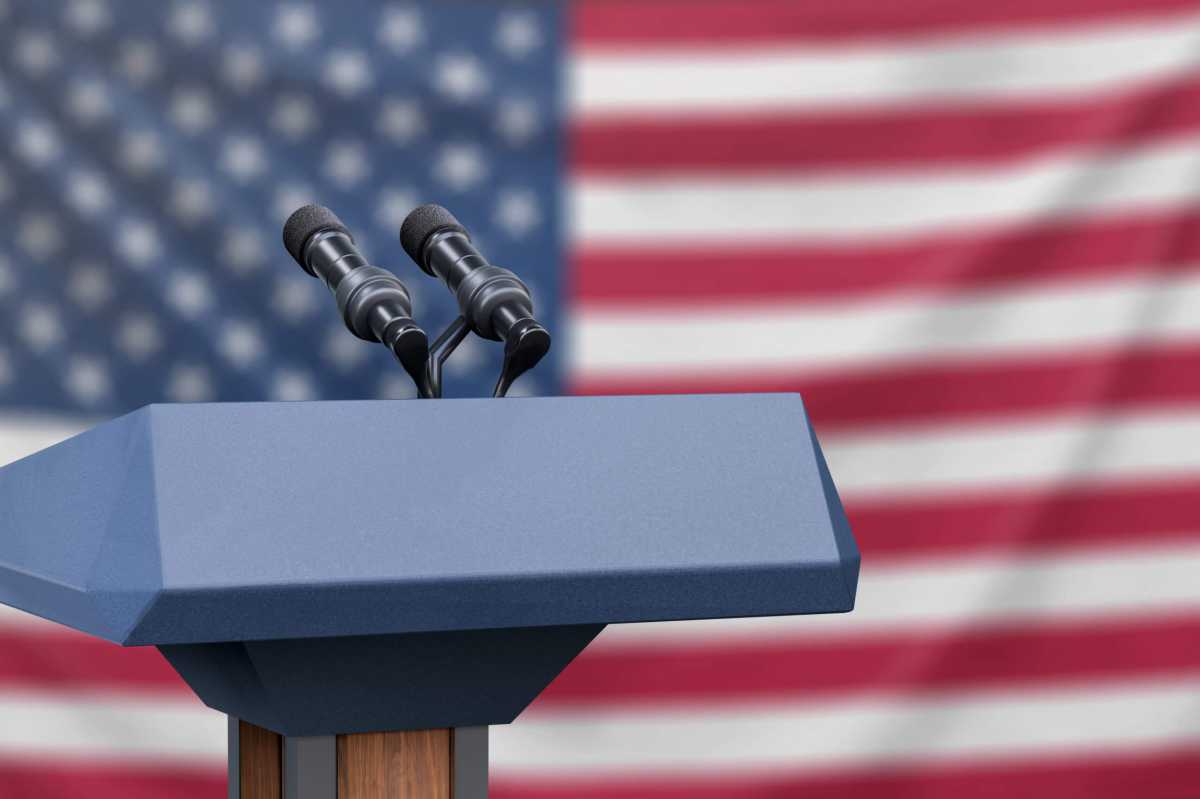 Flag of the United States at a press conference with microphones