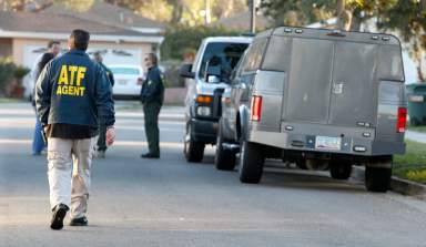 Police, FBI and Federal ATF agents prepare a robot to enter the home of William Lawrence Hunziker, 46, in Riverside, California