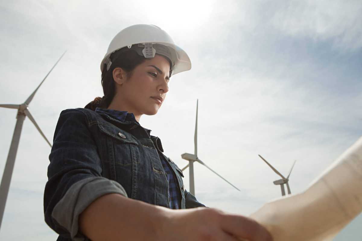Female engineer at wind farm with plans