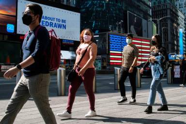 People wear masks around Times Square, as cases of the infectious coronavirus Delta variant continue to rise in New York City, New York