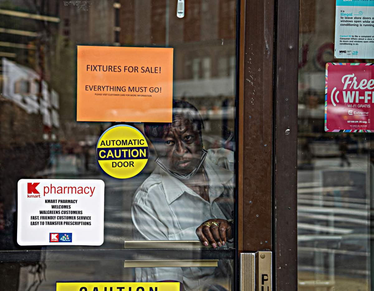 A security guard firmly locks Kmart's entrance doors