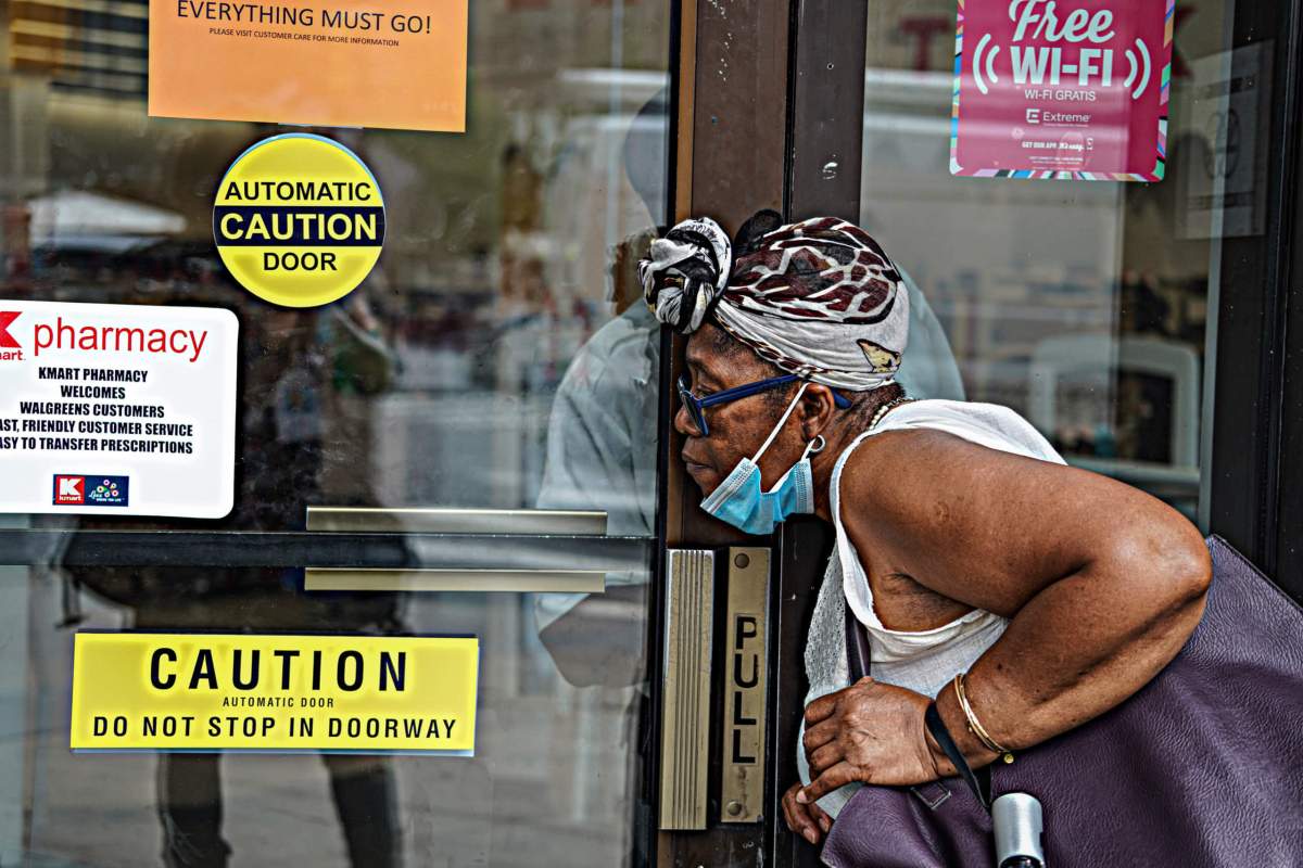 Loleta Rowe speaks to a security guard through glass doors