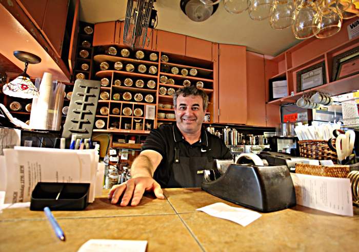 Owner of Organic Grill in Village behind counter