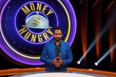Host Kal Penn poses, as seen on Money Hungry, Season 1.