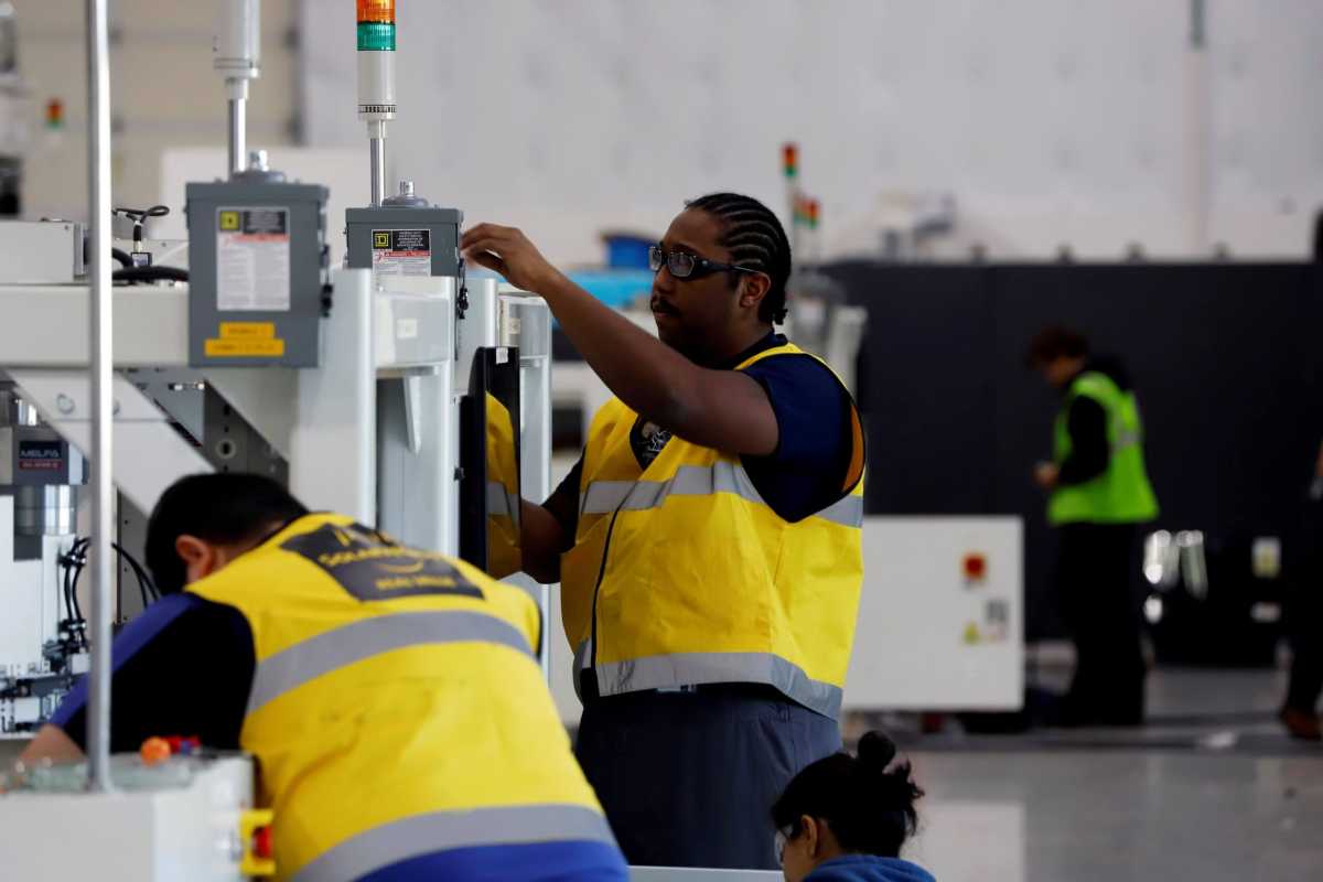 FILE PHOTO: SunPower equipment technicians install P-Series solar panel manufacturing technology at its Hillsboro manufacturing plant in Hillsboro