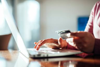 Woman shopping online with a credit card and pc.