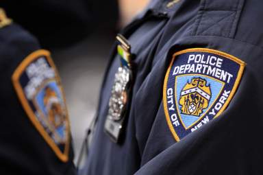 New York Police Department officers stand outside of a midtown Manhattan office building after evacuating workers that had been overcome by fumes in New York