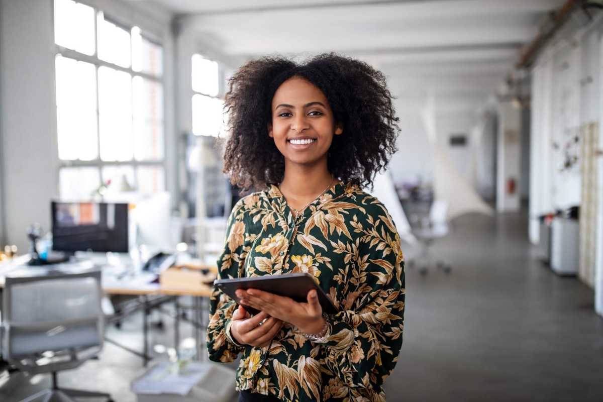 Confident businesswoman with digital tablet in office
